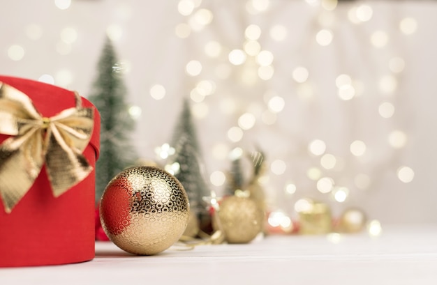 Rote Weihnachtsgeschenkbox mit einer goldenen Schleife auf dem Bokeh