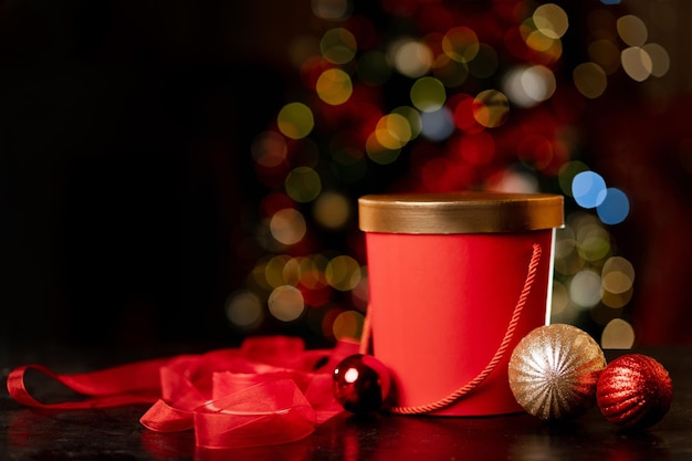 Rote Weihnachtsgeschenkbox und Verpackungsband auf Bokeh-Hintergrund Hochwertiges Foto