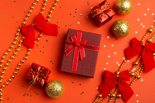 Rote Weihnachtsgeschenke und Weihnachtsbäume auf rotem Grund. Ein Artikel über das neue Jahr und Weihnachten. Die Auswahl an Geschenken. Ein rotes Geschenk.