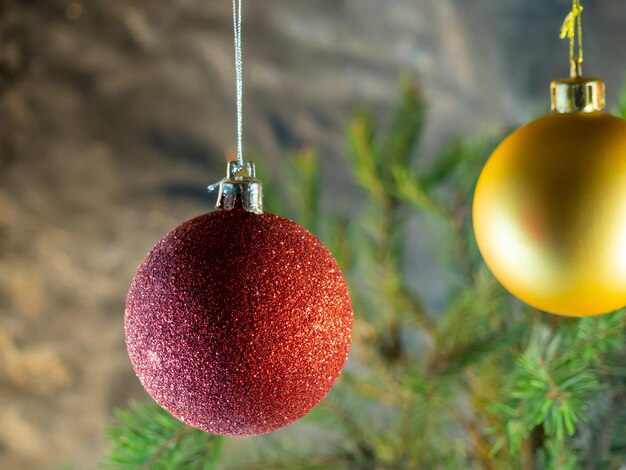 Rote Weihnachtskugel auf dem Hintergrund der Tannenzweige Weihnachtsdekoration