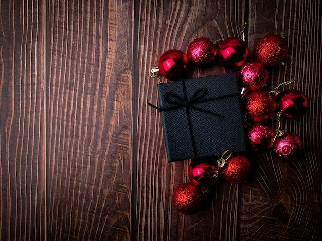 Rote Weihnachtskugel und Geschenkbox auf einem Holztisch Feiertage Weihnachten Hintergrund Kopieren Sie Platz für Text oder Design Ansicht von oben