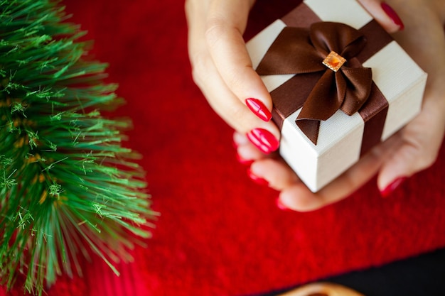 Rote Weihnachtsmaniküre machen im Schönheitsstudio auf Weihnachtshintergrund.