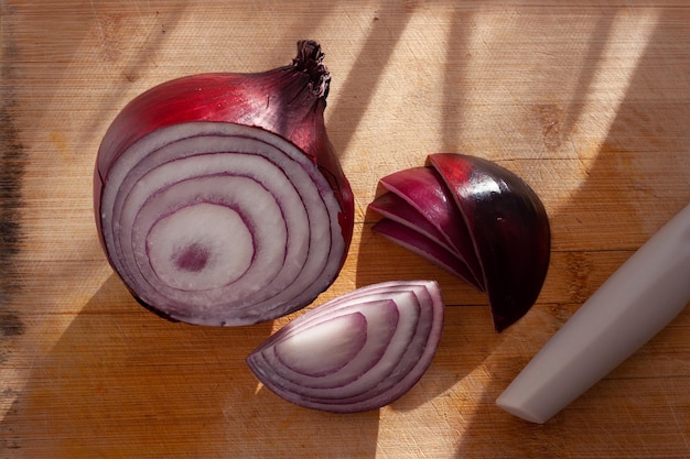 Rote Zwiebel in Stücke geschnitten auf einem Holzbrett