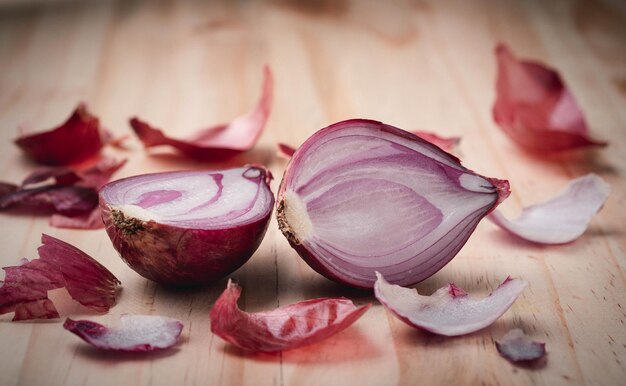 Rote Zwiebel und rote Zwiebelscheiben auf Holztisch