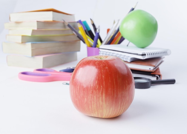 Foto roter apfel auf dem hintergrund des schulmaterialkonzepts der bildung