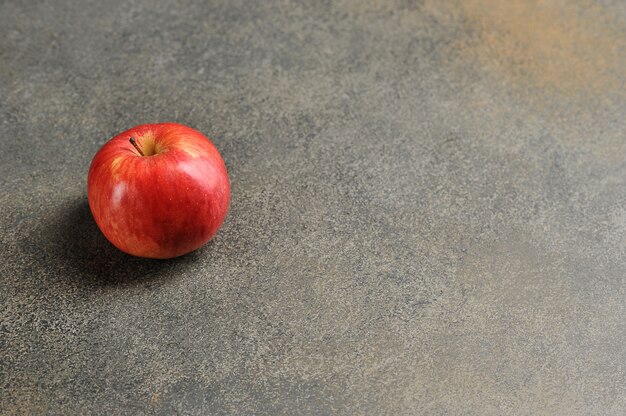 Roter Apfel auf grauem Hintergrund - Draufsicht