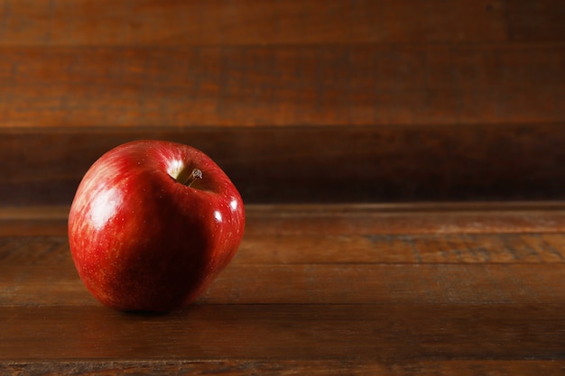 Roter Apfel auf hölzernem Hintergrund