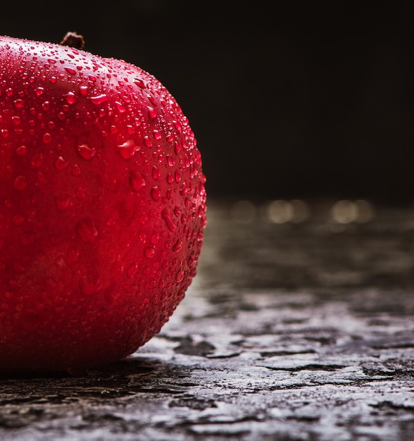 Roter Apfel hautnah Frischer roter Apfel auf einer schwarzen Hintergrundtextur