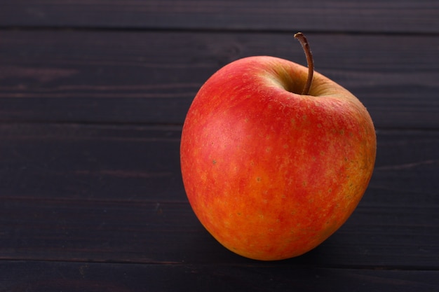 Roter Apfel Pinova auf einem dunklen Hintergrundplatz