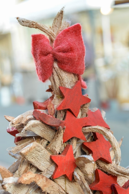 Roter Bogen und Holzsterne auf einem hölzernen Weihnachtsbaum