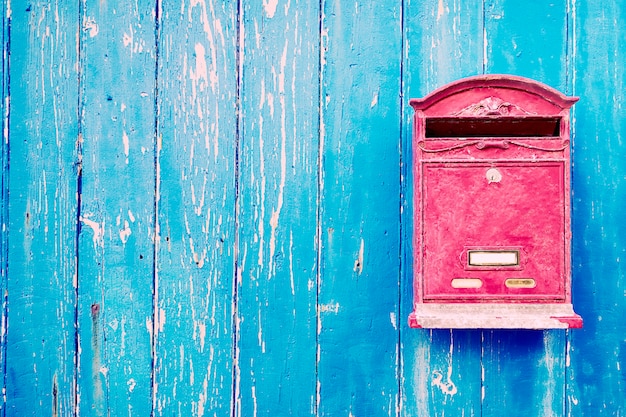 Roter Briefkasten an blauer Holztür