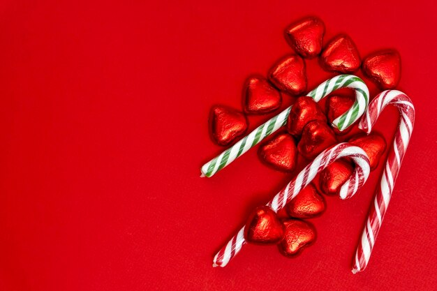Roter festlicher Weihnachtshintergrund mit Süßigkeiten in Form von Herzen