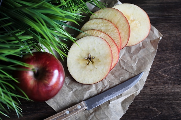 Roter frischer Apfel auf einem hölzernen strukturierten Küchentisch