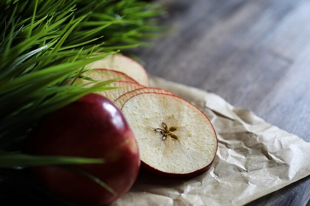 Roter frischer Apfel auf einem hölzernen strukturierten Küchentisch