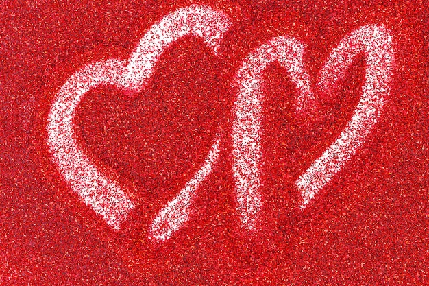 Roter Glitzerhintergrund mit einem mit dem Finger gezeichneten Herzen. Valentinstag Hintergrund