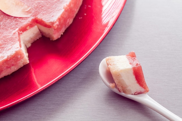 Foto roter käsekuchen und stück davon in einem löffel