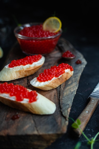 Roter Kaviar auf dunklem Hintergrund Sandwiches mit Kaviar