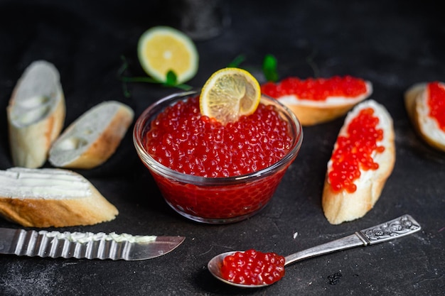 Roter Kaviar auf dunklem Hintergrund Sandwiches mit Kaviar