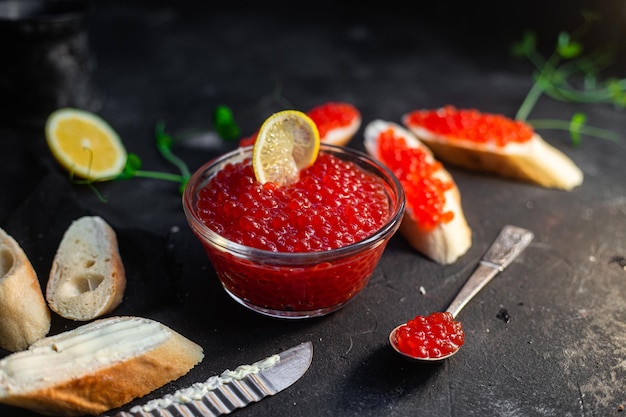 Roter Kaviar auf dunklem Hintergrund Sandwiches mit Kaviar