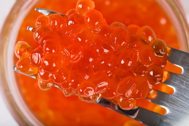 Roter Kaviar auf einer Metallgabel. Extreme Nahaufnahme