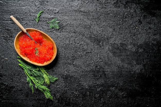 Roter Kaviar in einer Schüssel mit einem Löffel und Dill