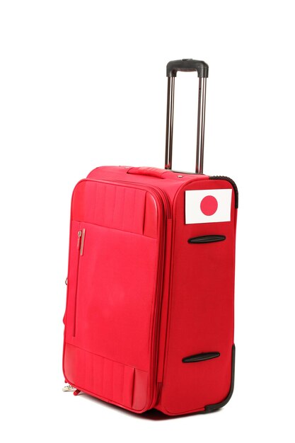 Roter Koffer mit Aufkleber mit Flagge Japans isoliert auf weiß