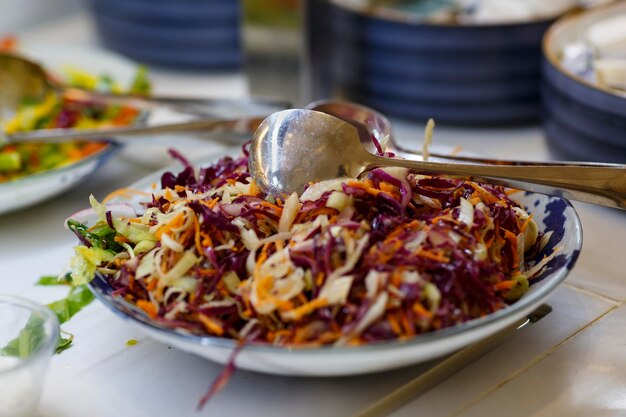 Foto roter kohlsalat kohlsalat in einer schüssel selektiver fokus frischer und gesunder salat in einer schüssel auf dem küchentisch gemüsesalat und eiserner löffel in einer schüssel großer löffel mit rotem kohl