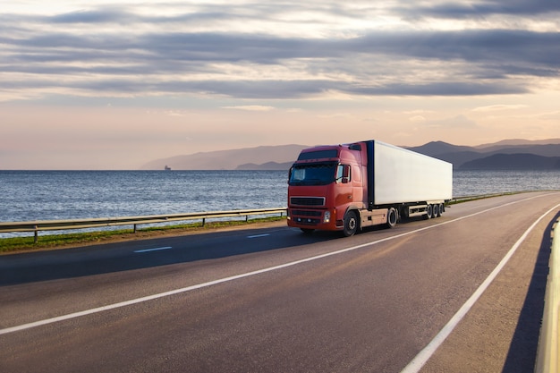 Roter LKW auf einer Straße nahe dem Meer