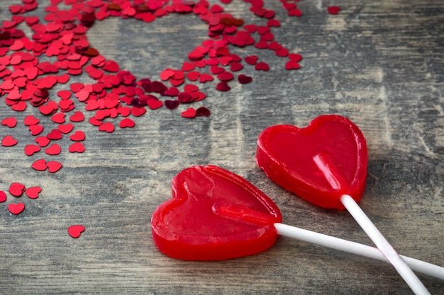Roter Lutscher mit Herzform auf hölzernem Hintergrund Liebeskonzept Valentinstag