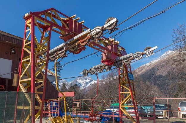 Roter Motormechanismus zum Anheben von Touristen in die Berge an einem sonnigen Tag vor blauem Himmel Aktiver Wintersport und Erholung