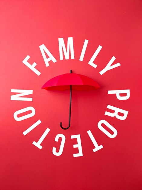 Roter Regenschirm mit dem Wort FAMILY PROTECTION auf rotem Hintergrund
