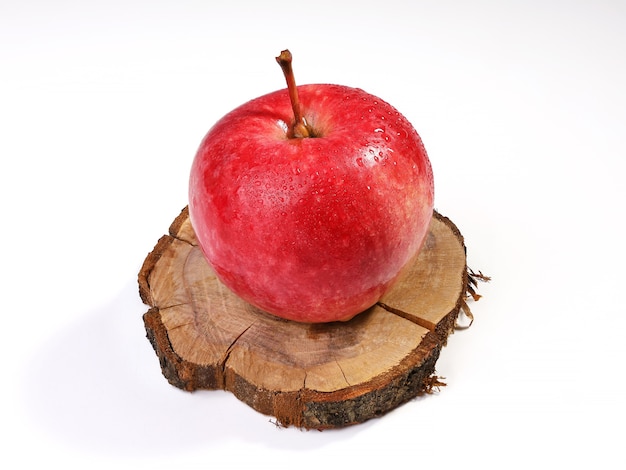 Roter reifer Apfel mit Wassertropfen auf Kreisapfelbaumstumpf