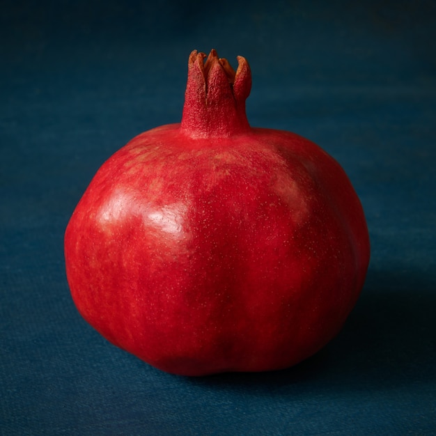 Roter reifer Granatapfel auf blauem Hintergrund