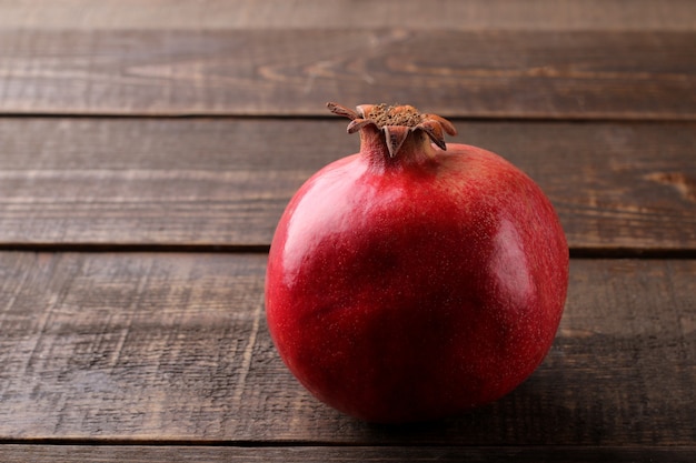 Roter reifer Granatapfel auf einem Holztisch