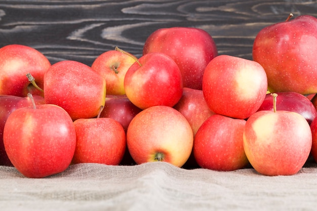Roter reifer und saftiger Apfel mit Zimtstangen, ein köstliches Dessert aus Früchten und Gewürzen