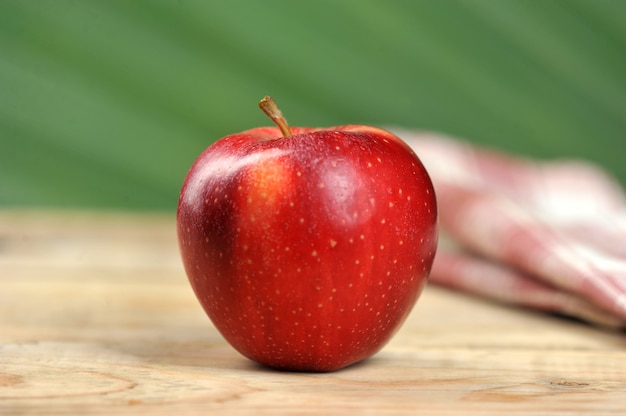 Roter saftiger Apfel auf hölzernem Hintergrund