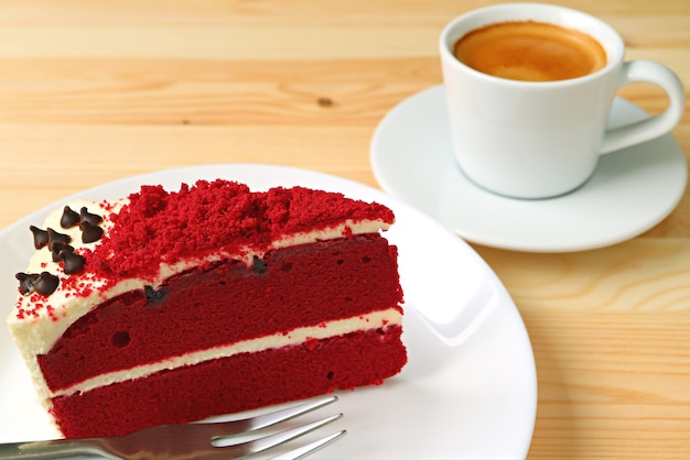 Roter Samt-Shortcake mit Frischkäse-Bereifen und eine Schale heißer Kaffee im Hintergrund