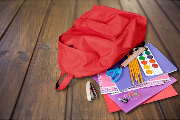 Roter Schulrucksack im Hintergrund.