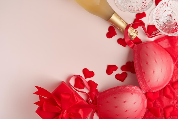 Roter sexy BH und Höschen in Box auf rosa Hintergrund Frauen sexy Unterwäsche Set mit Rosen und Parfüm Geschenkidee für Frauentag oder Valentinstag mit Kopierbereich Überraschung für Männer oder für ihn Ansicht von oben