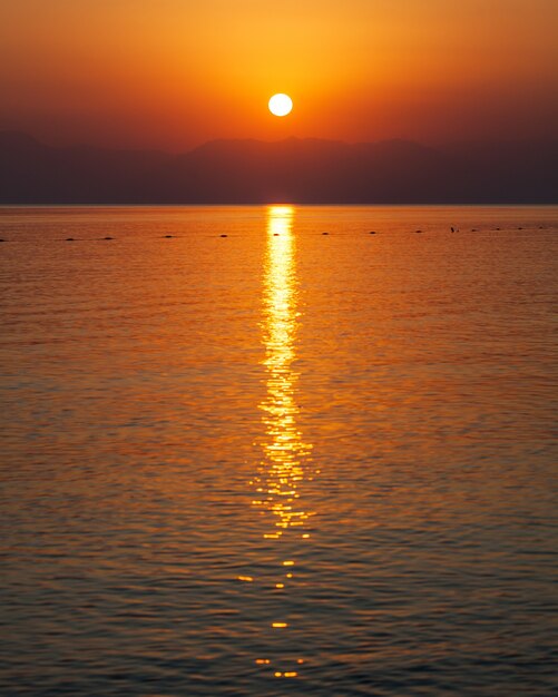 Foto roter sonnenuntergang am meer über den bergen