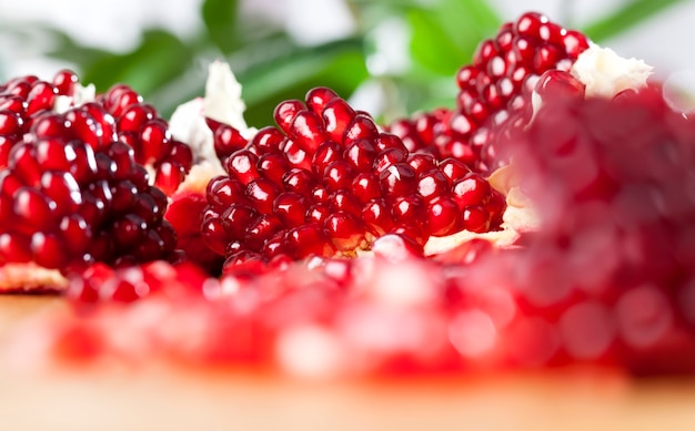 Roter und reifer Granatapfel mit saftigen Körnern, leckerer und gesunder Granatapfel in mehrere Teile geteilt, Fruchtgranatapfel-Nahaufnahme