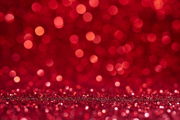 Roter verschwommener abstrakter glänzender Valentinstaghintergrund mit festlichem Glitzerfunkeln des Bokeh-Effekts