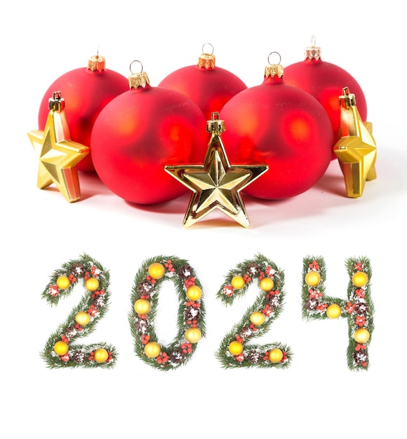 Foto roter weihnachtsball und die nummer 2024 von weihnachtenbaumzweigen auf weißem hintergrund