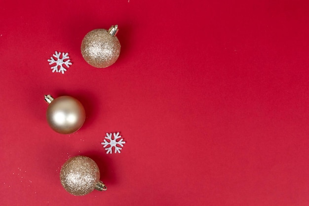 Roter weihnachtshintergrund mit goldenen kugeln und silbernen schneeflocken draufsicht mit kopienraum