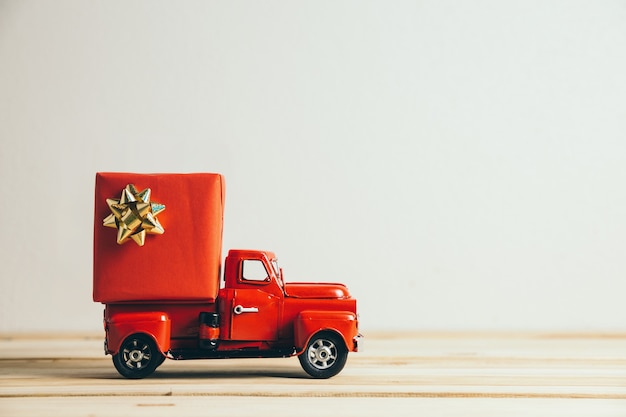 Roter Weihnachtslastwagen und Geschenk. Frohe Weihnachten und ein gutes neues Jahr Konzept.