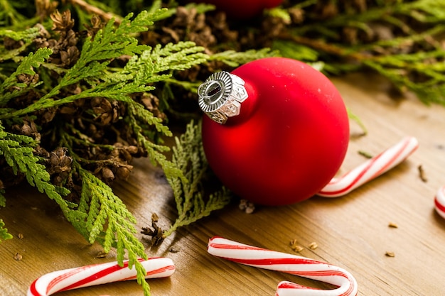 Roter Weihnachtsschmuck auf Tisch aus gebeiztem Holz.