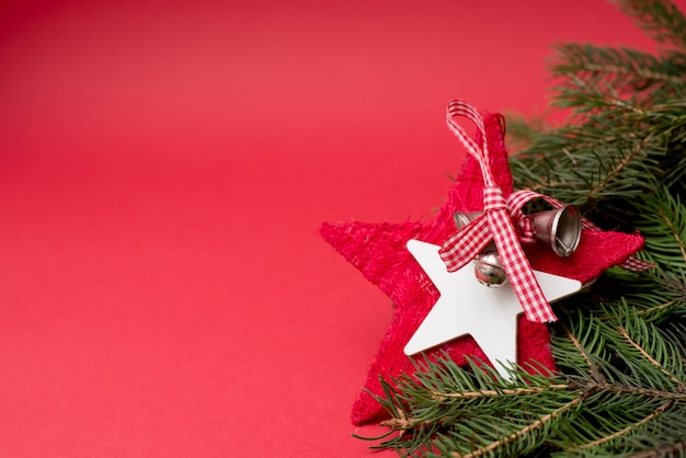 Roter Weihnachtsstern mit Glocken auf rotem Hintergrund