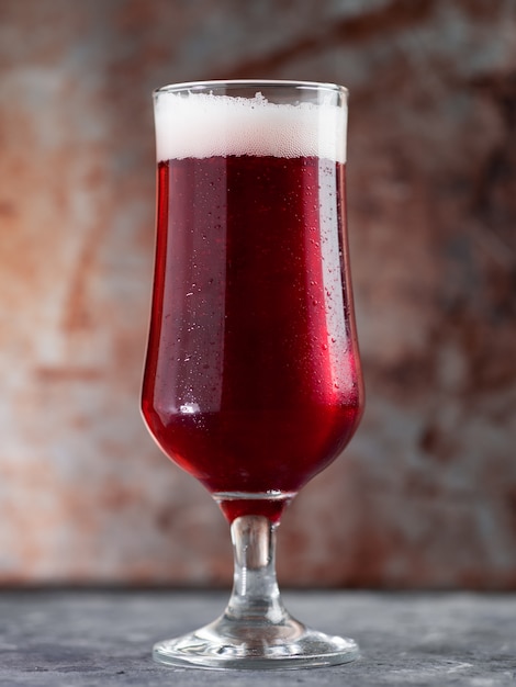 Rotes Alebier in einem Glas auf einem rostigen Metallhintergrund