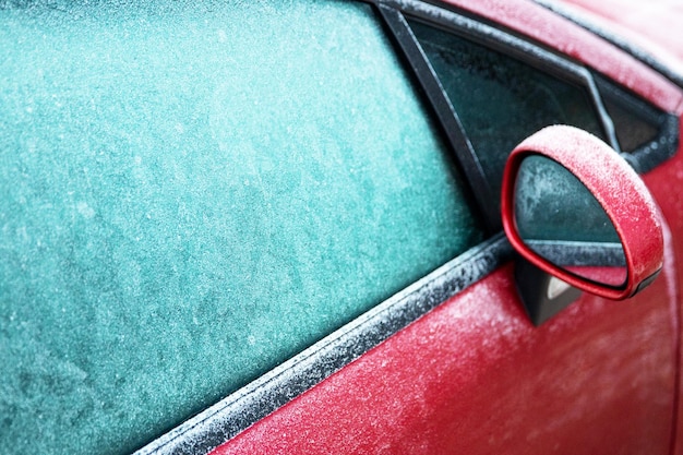 Rotes Auto auf der Straße mit gefrorenen Fenstern