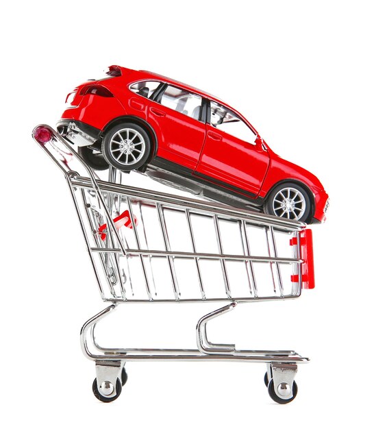 Foto rotes auto im einkaufswagen isoliert auf weiß